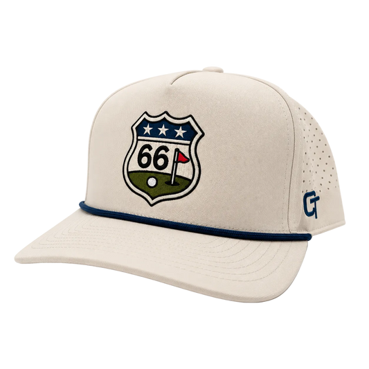 A beige baseball cap with a navy blue embroidered '66' shield patch on the front, featuring a golf flag design and a blue 'CT' logo on the side mesh, set against a plain white background.