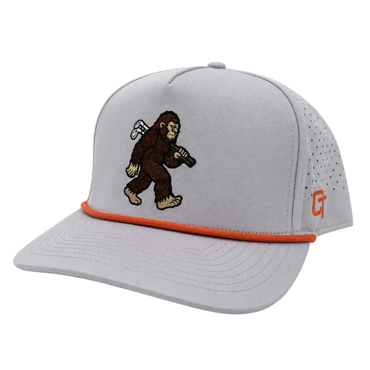 A light gray structured baseball cap with a curved brim, featuring an embroidered brown Bigfoot figure on the front, an orange accent line under the brim, and a small orange 'CT' logo on the side.
